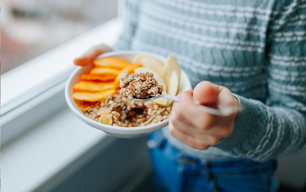 Imagem de uma cliente de uma loja, consumindo cereais naturais para auxiliar em sua alimentação mais saudável.