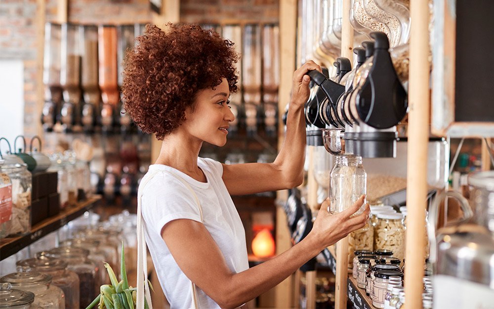 Mulher em uma loja de produtos naturais satisfeita com os distribuidores escolhidos.