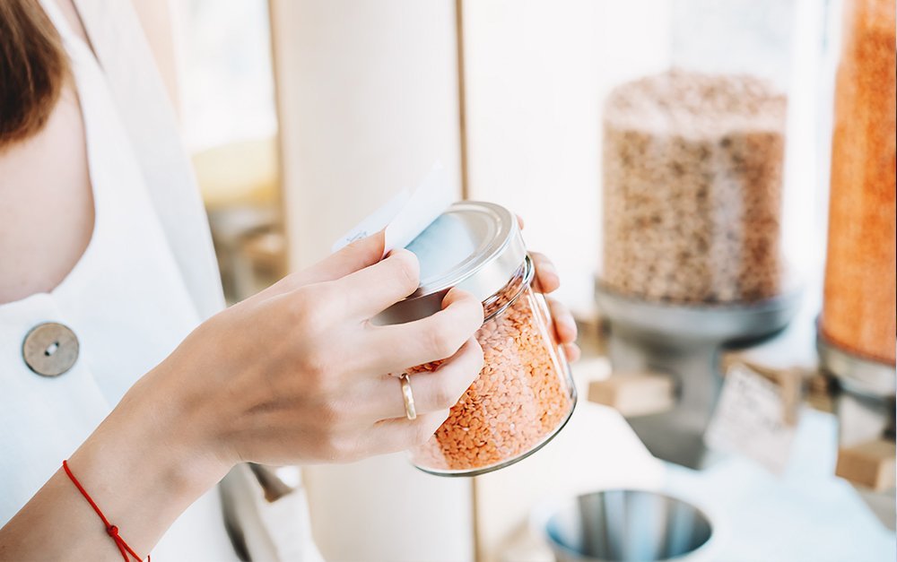 Imagem de uma dona de loja de produtos naturais organizando os produtos que irá vender em sua loja.