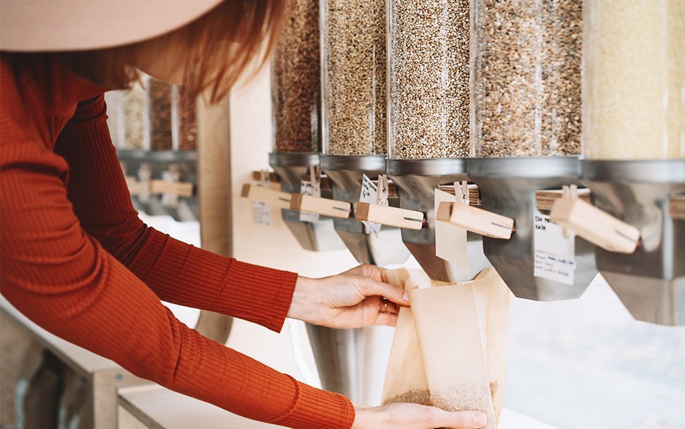imagem de uma mulher, dona de uma loja de produtos naturais, utilizando uma diversidade de produtos naturais para lidar com a concorrência dos demais.